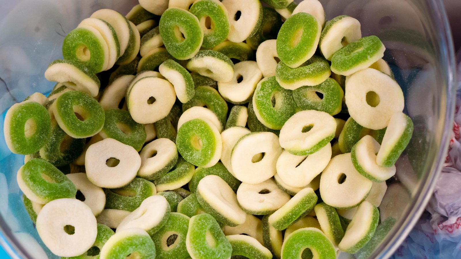 Bin of green and white gummy apple rings at Sugar Me Up in Avondale