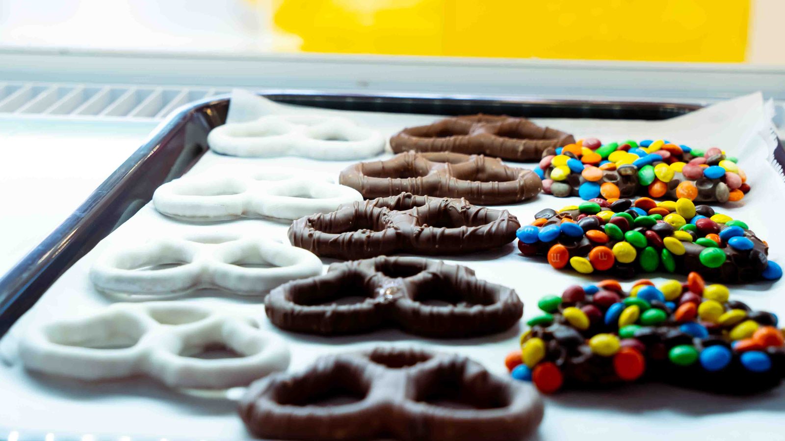 Tray of chocolate covered pretzels topped with candy pieces