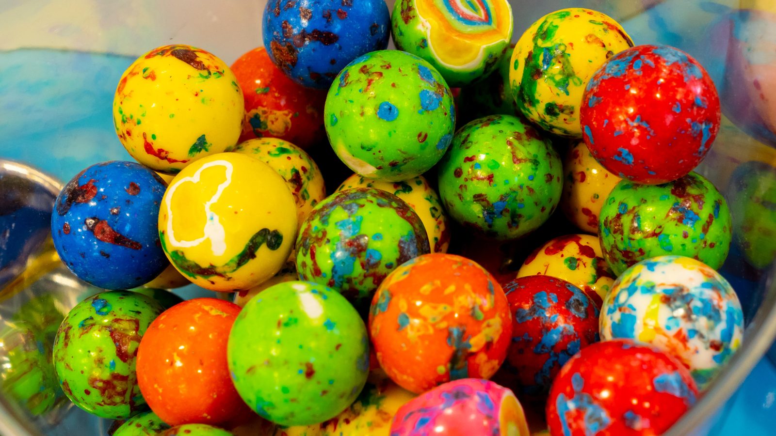 Colorful speckled jawbreakers and gumballs in a glass jar