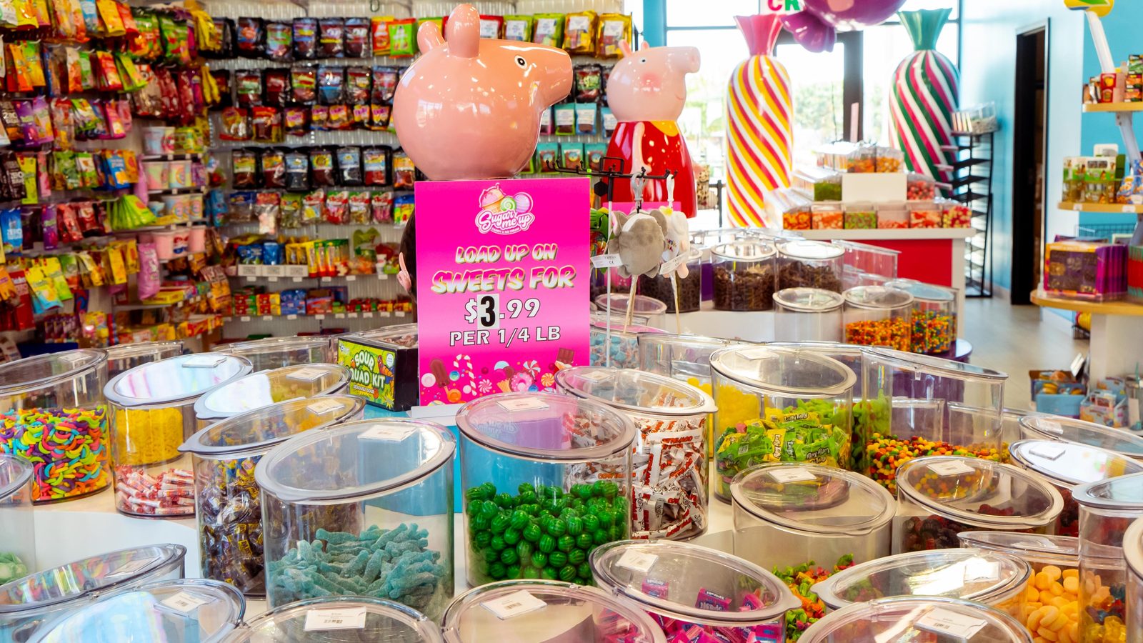 Covered bulk candy bins filled with gummies and chocolates