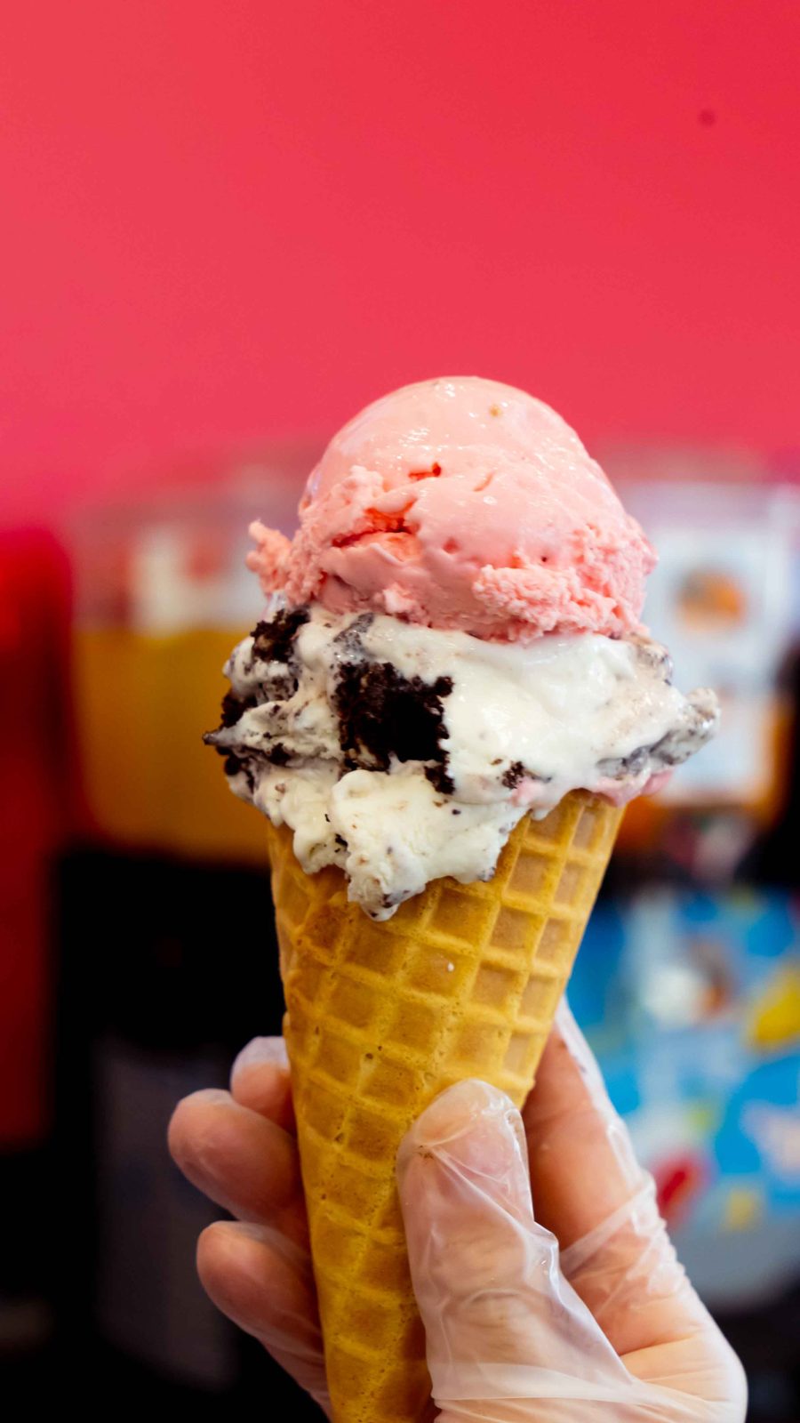 Fresh scooped ice cream cone in front of a bright pink wall