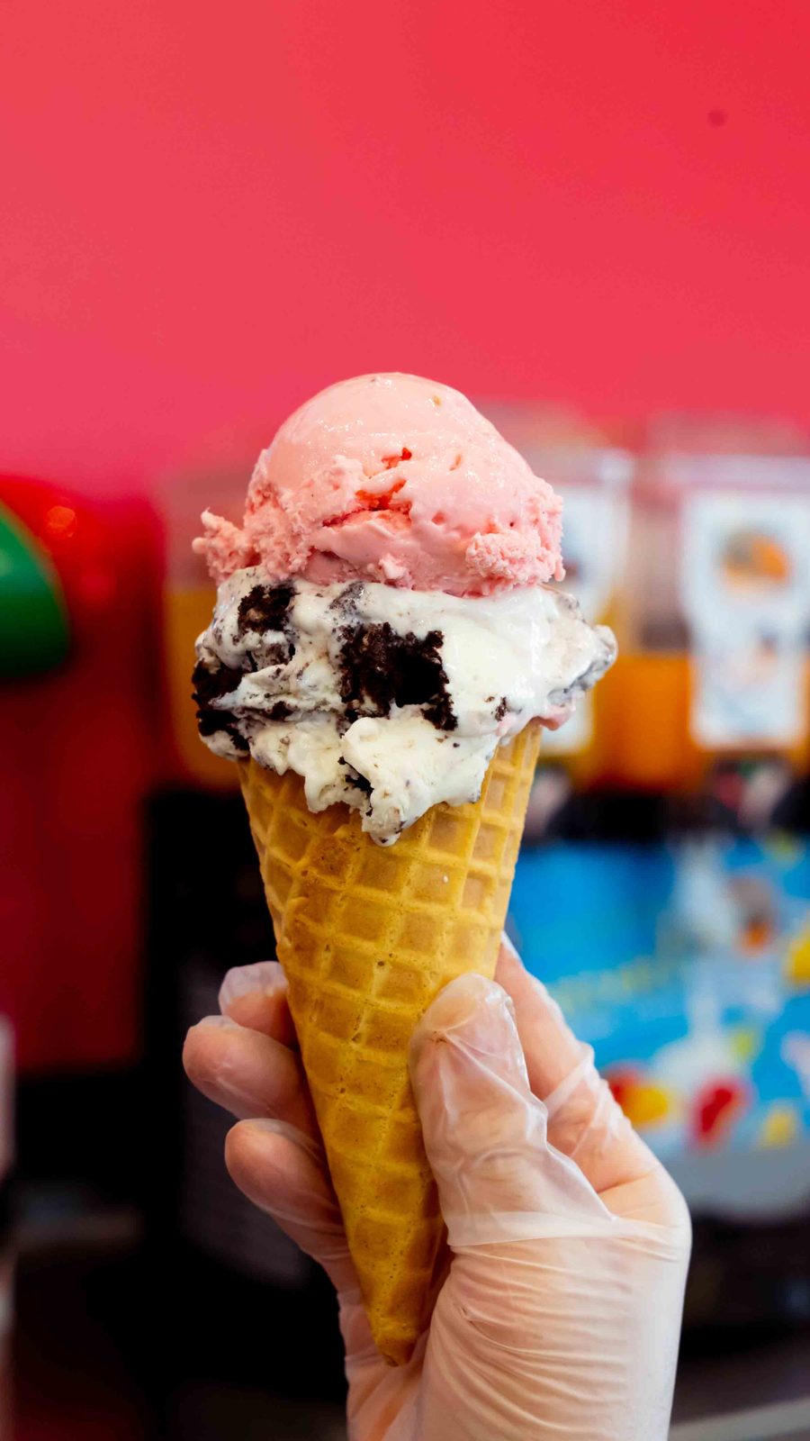 Waffle cone with strawberry and cookies and cream ice cream scoops